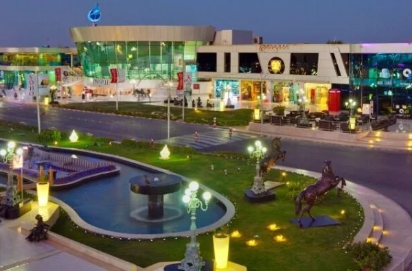 صورة لساحة سوهو في شرم الشيخ ليلاً، تعرض الأضواء الملونة، وعروض الموسيقى والرقص، والنافورات الراقصة، وسط جو مليء بالحيوية والترفيه